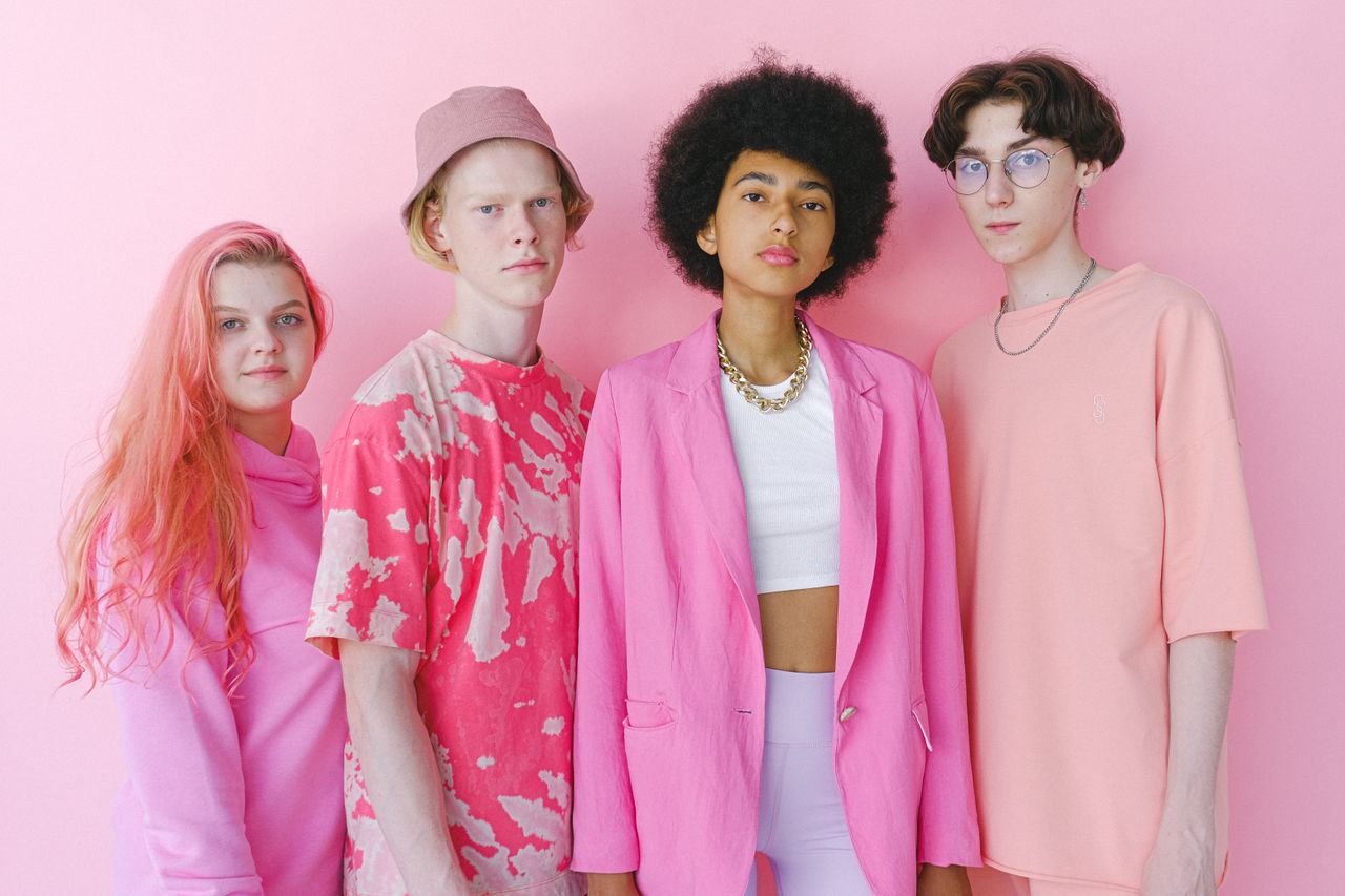 brand-01 Diverse teenage friends in trendy outfits looking at camera on pink background of studio